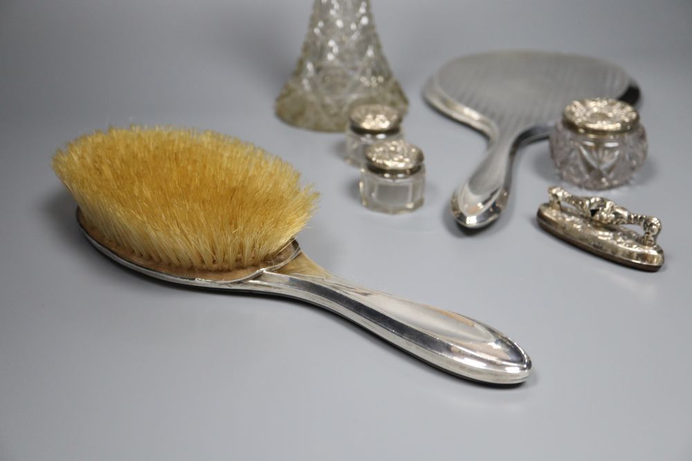 A silver-mounted conical glass scent bottle, sundry other silver-mounted toilet items and an engine-turned silver compact.
